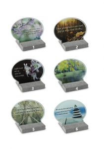 Oval shaped memorial marker with several designs on glass plate